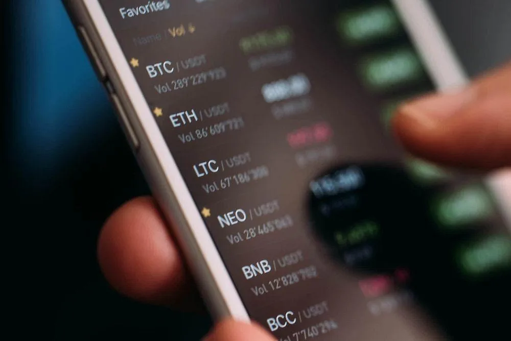 Смартфон с криптовалютным кошельком и монетой биткоин рядом